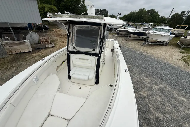 Slide: The Image of 2008 Robalo R300 Center Console boat with spacious seating, parked outdoors. - 12