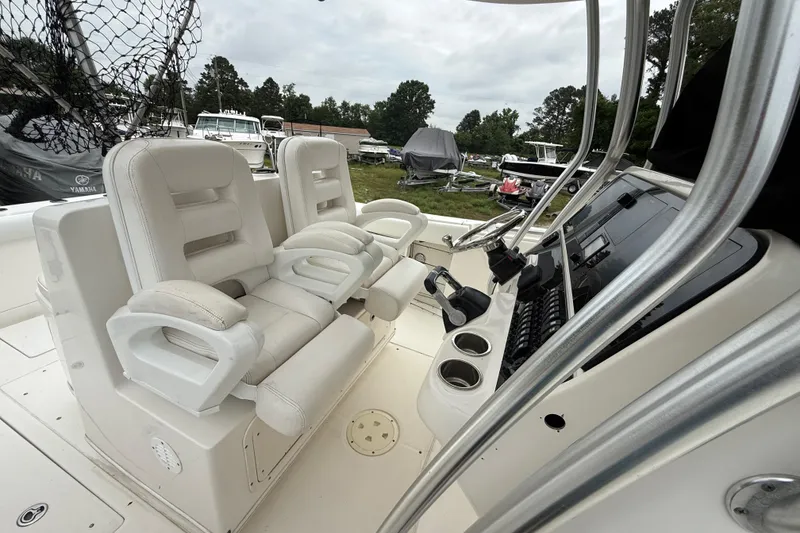 Slide: The Image of 2008 Robalo R300 Center Console boat interior with white seating and control panel. - 14