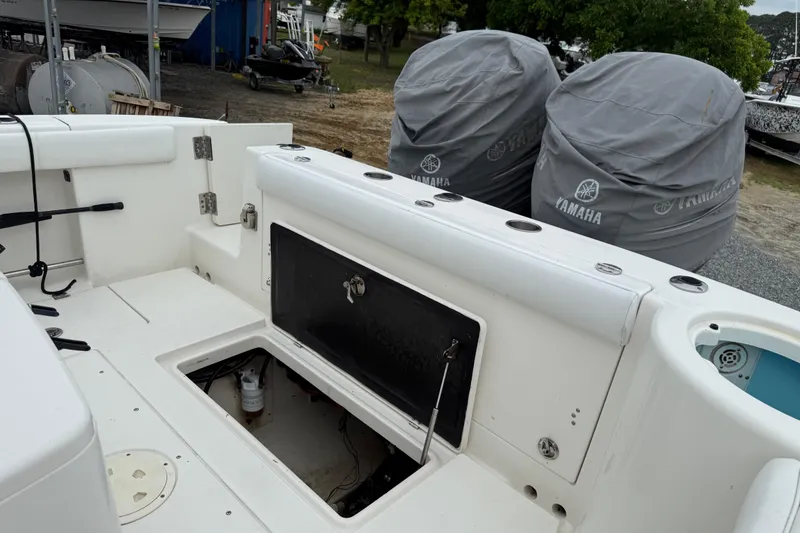 Slide: The Image of 2008 Robalo R300 Center Console boat interior with storage compartments and Yamaha engine covers. - 19