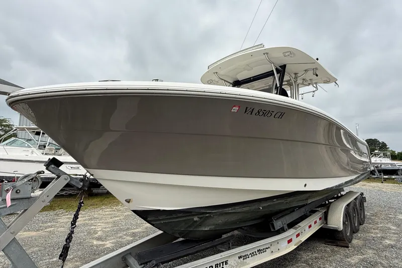 Slide: The Image of 2008 Robalo R300 Center Console boat on trailer, side view under cloudy sky. - 2