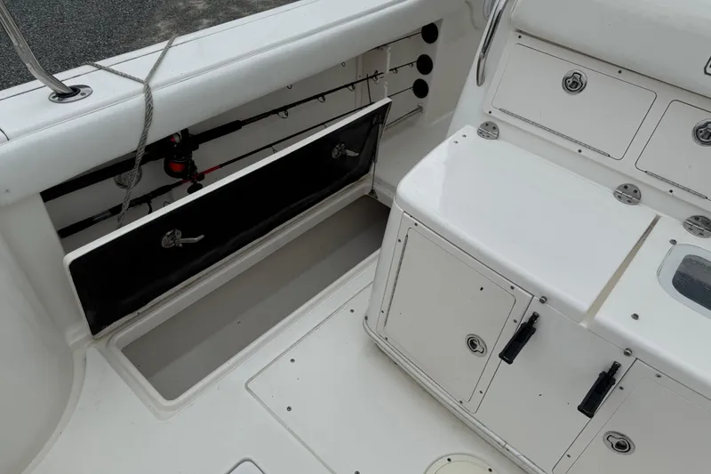 Slide: The Image of 2008 Robalo R300 Center Console boat interior with storage compartments and fishing rod holders. - 20
