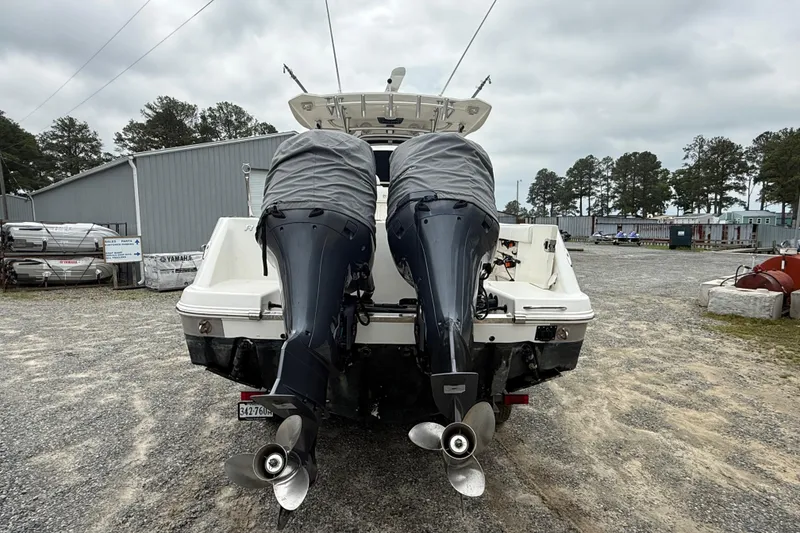 Slide: The Image of 2008 Robalo R300 Center Console boat with twin outboard motors in a storage yard. - 23