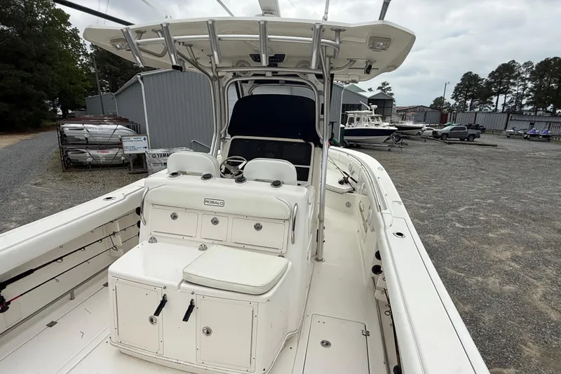Slide: The Image of 2008 Robalo R300 Center Console boat in a marina with storage buildings. - 24
