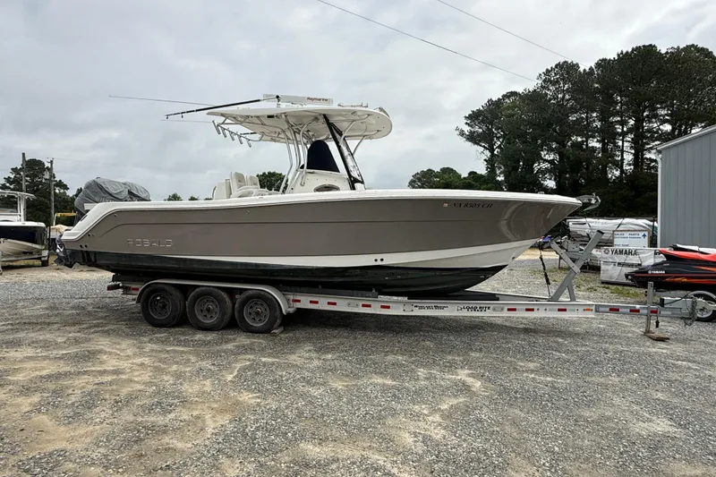Slide: The Image of 2008 Robalo R300 Center Console boat on a trailer, parked outdoors. - 29