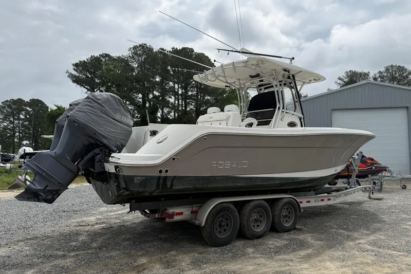 Slide: The Image of 2008 Robalo R300 Center Console boat on trailer, parked outdoors near a storage facility. - 4