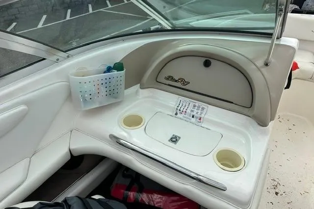 Slide: The Image of Interior of a 1998 Sea Ray 210 Bow Rider boat with storage and cup holders. - 15