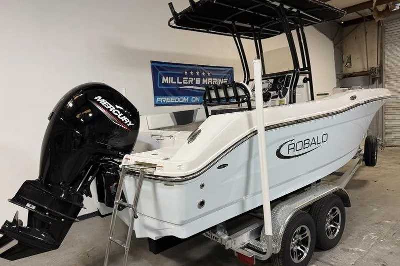 Slide: The Image of 2026 Robalo R200 Center Console boat with Mercury engine on trailer in showroom. - 3