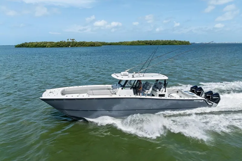 Slide: The Image of 2020 Freeman 42LR boat cruising on open water with island in background. - 1