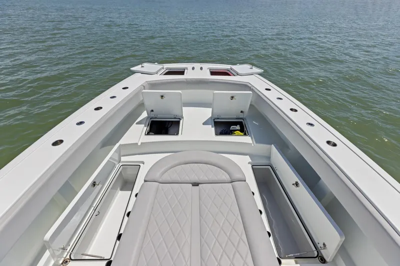 Slide: The Image of Bow view of 2020 Freeman 42LR boat with open storage compartments on calm water. - 35