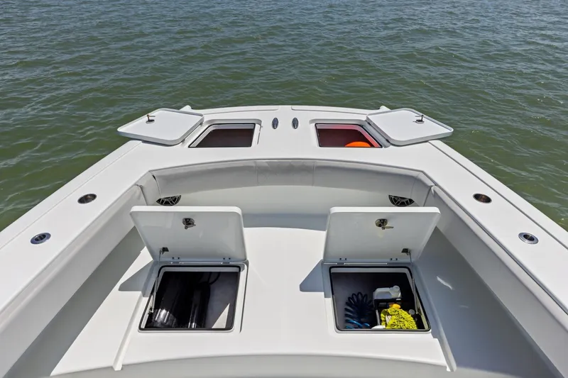 Slide: The Image of Bow view of 2020 Freeman 42LR boat with open storage compartments on the water. - 36