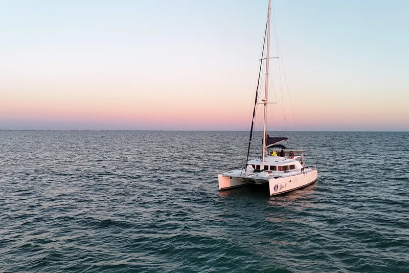 The Image of Lagoon 440 catamaran 2009 sailing at sunset on open sea. - 1