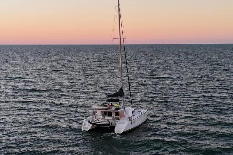 Slide: The Image of 2009 Lagoon 440 catamaran sailing at sunset on the ocean. - 4