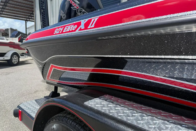 Slide: The Image of 2026 Phoenix 921 Elite X II boat with sleek red and black design. - 2