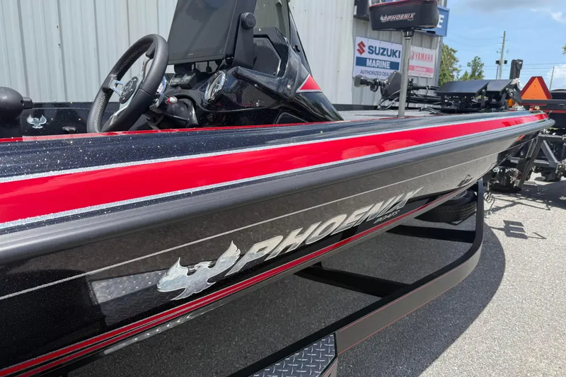 Slide: The Image of 2026 Phoenix 921 Elite X II boat with sleek red and black design, parked outdoors. - 3