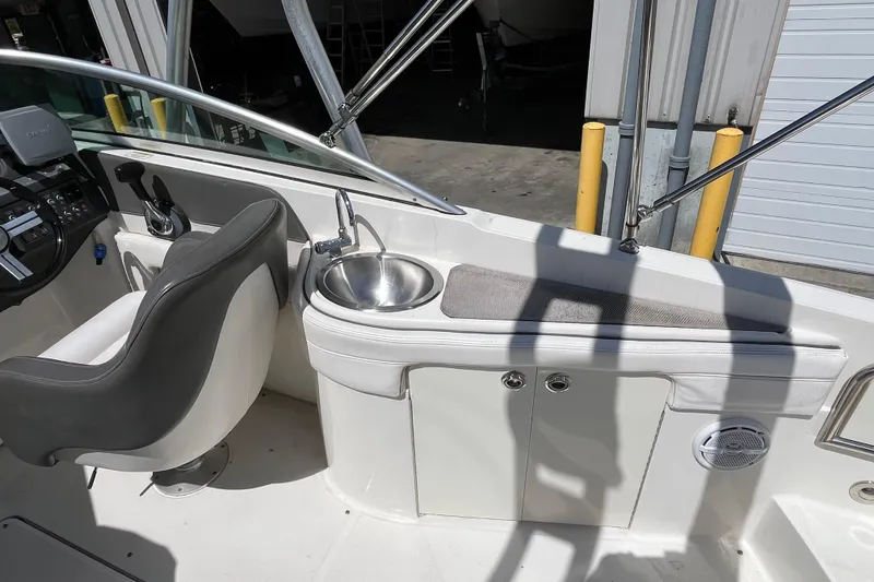 Slide: The Image of 2011 Sea Ray 260 Sundeck interior with helm seat and sink. - 13