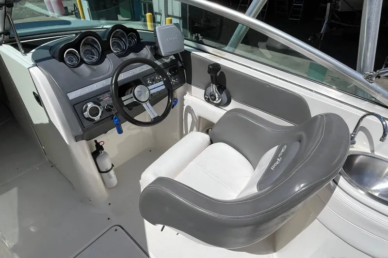 Slide: The Image of 2011 Sea Ray 260 Sundeck cockpit with steering wheel, gauges, and seating. - 14