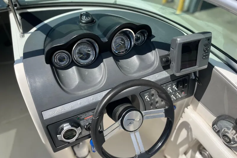 Slide: The Image of Dashboard of a 2011 Sea Ray 260 Sundeck boat with steering wheel and gauges. - 17