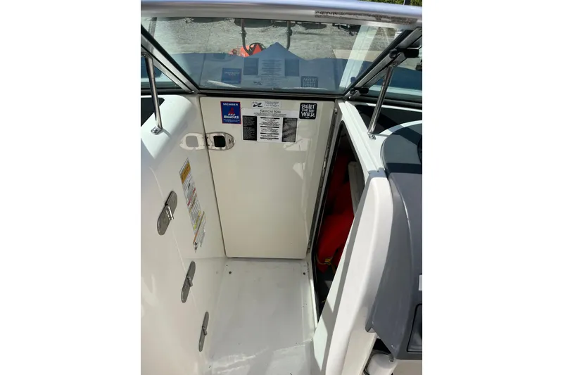 Slide: The Image of 2011 Sea Ray 260 Sundeck interior with safety labels and storage compartment. - 21
