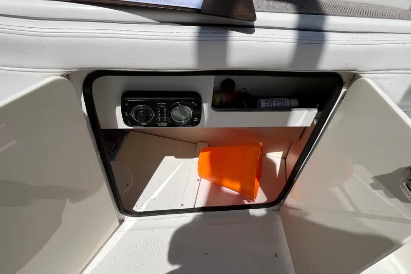 Slide: The Image of 2011 Sea Ray 260 Sundeck storage compartment with Sony stereo and safety equipment. - 27