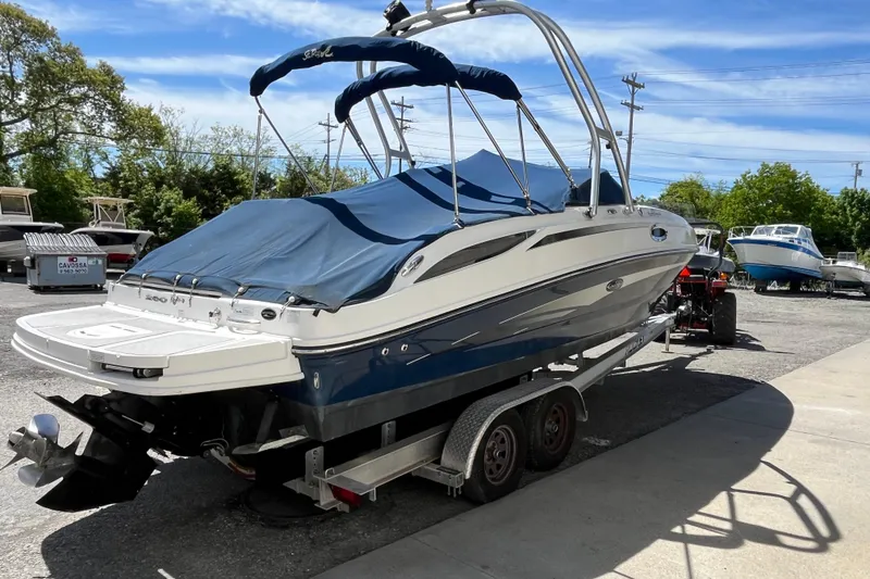 Slide: The Image of 2011 Sea Ray 260 Sundeck boat on trailer, covered and parked outdoors. - 3
