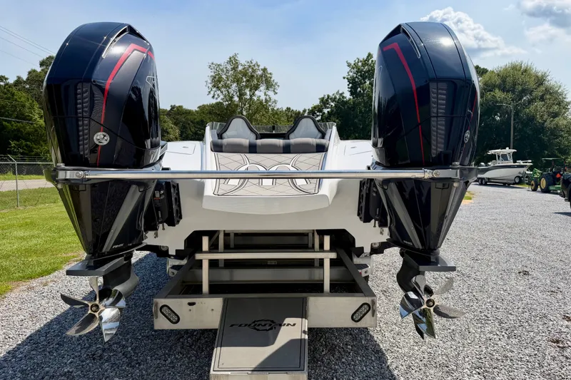 Slide: The Image of 2024 Fountain 34 Thundercat boat with dual outboard engines on gravel surface. - 34