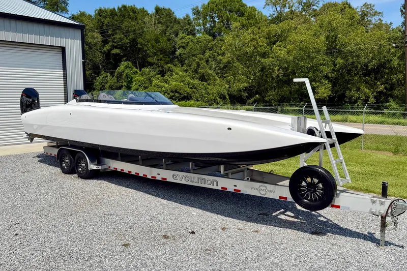 Slide: The Image of 2024 Fountain 34 Thundercat powerboat on trailer, parked outdoors near a garage. - 32