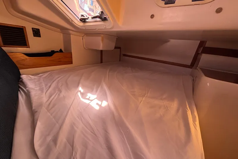 Slide: The Image of Cozy cabin interior of a 2006 Catalina 320 sailboat with sunlight through hatch. - 32
