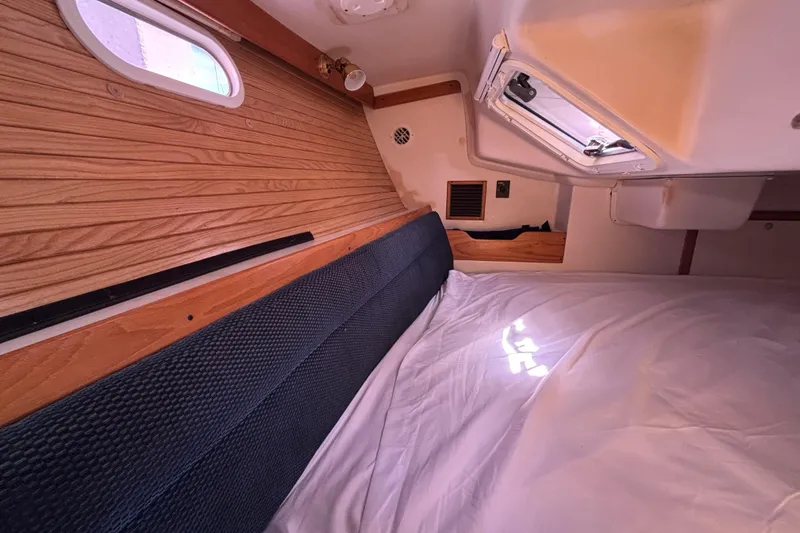 Slide: The Image of Cozy cabin interior of 2006 Catalina 320 sailboat with wood paneling and bedding. - 33