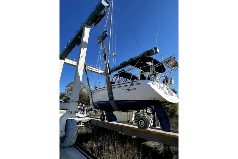 Slide: The Image of Catalina 320 sailboat from 2006 being lifted by a crane at a marina. - 36