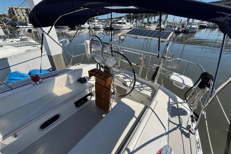 Slide: The Image of Cockpit of a 2006 Catalina 320 sailboat docked at a marina, featuring a steering wheel and seating. - 6