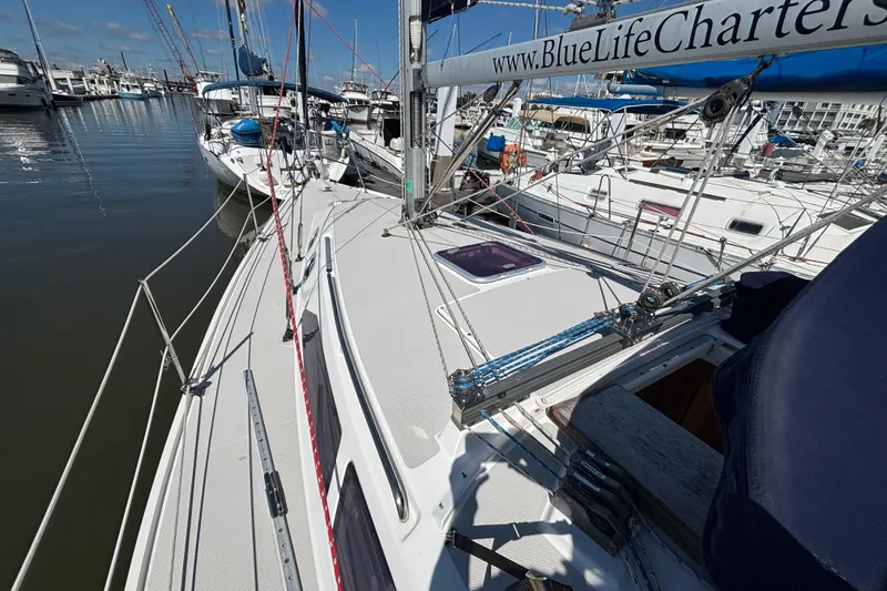 Slide: The Image of 2006 Catalina 320 sailboat docked at marina, featuring deck and rigging details. - 9