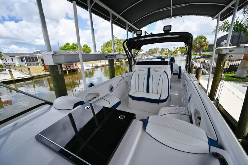 Slide: The Image of 2018 Renegade 32' Cuddy boat interior with luxurious seating and waterfront view. - 10