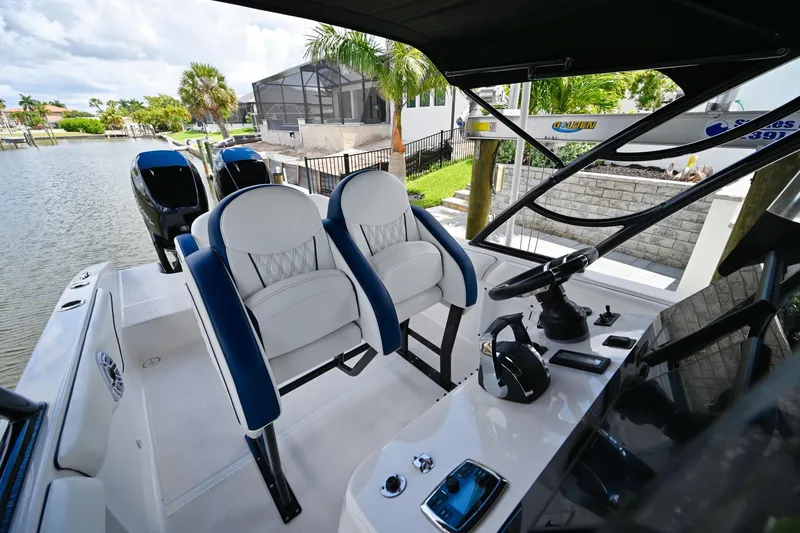 Slide: The Image of 2018 Renegade 32' Cuddy boat interior with dual seats and steering console. - 11