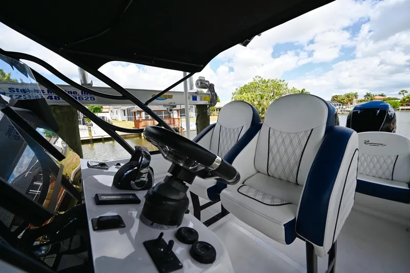 Slide: The Image of 2018 Renegade 32' Cuddy boat interior with steering wheel and cushioned seats. - 12