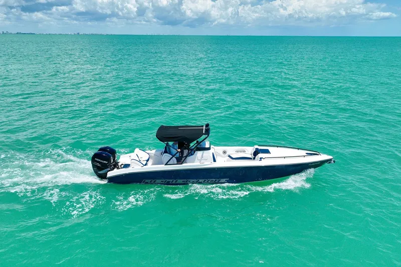 Slide: The Image of 2018 Renegade 32' Cuddy boat cruising on turquoise ocean waters under a cloudy sky. - 15