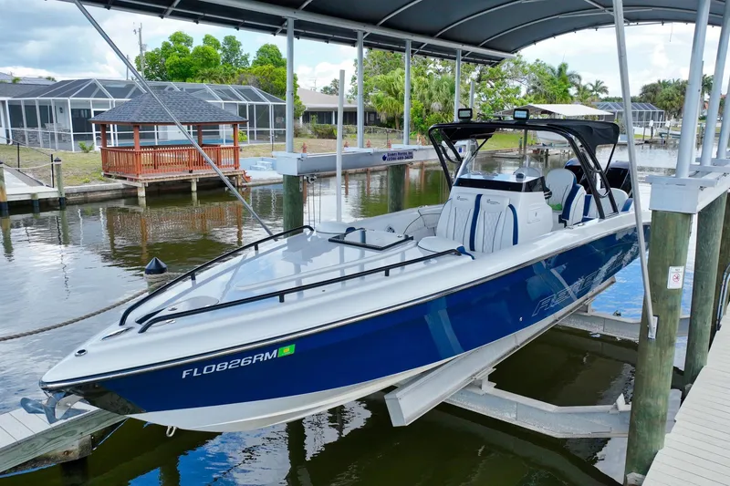 Slide: The Image of 2018 Renegade 32' Cuddy boat on a lift at the dock. - 2