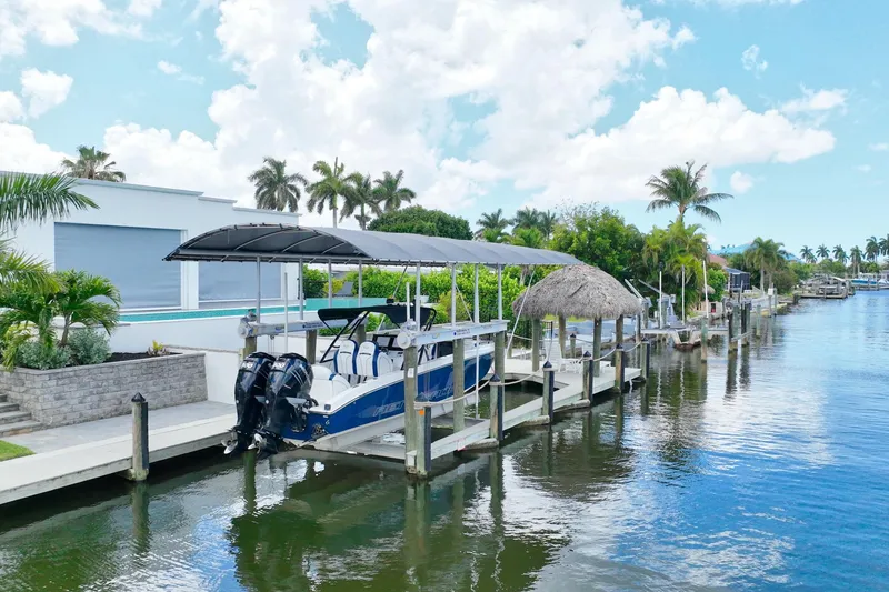 Slide: The Image of 2018 Renegade 32' Cuddy boat docked by a waterfront home with palm trees. - 3