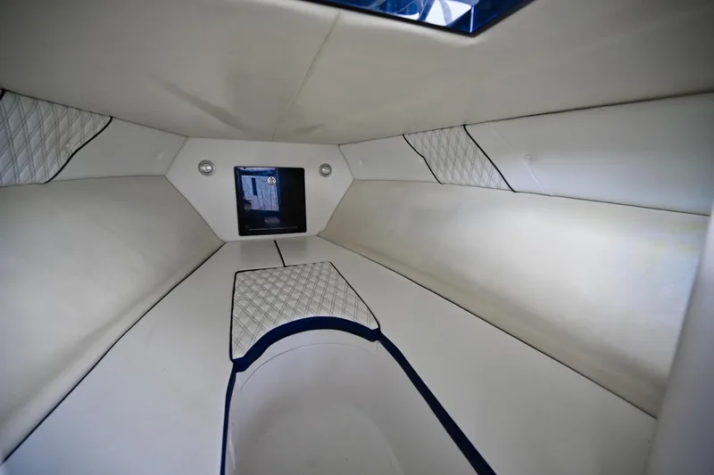 Slide: The Image of Interior of 2018 Renegade 32' Cuddy boat with white cushioned seating and storage. - 9