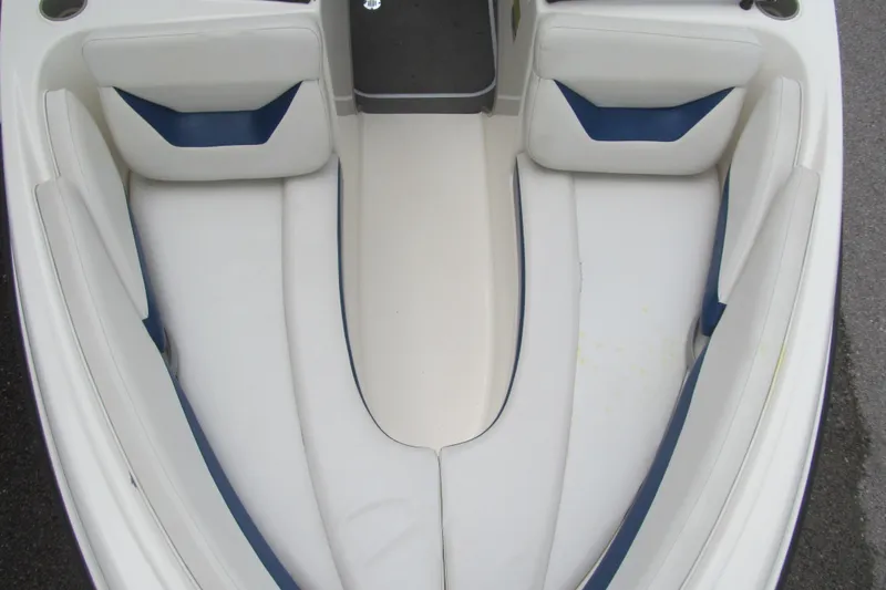 Slide: The Image of Interior view of a 2005 Bayliner 185 boat, featuring white and blue seating. - 9