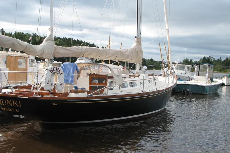 The Image of 1970 Hinckley Bermuda 40 sailboat docked, featuring classic design and covered sails. - 0