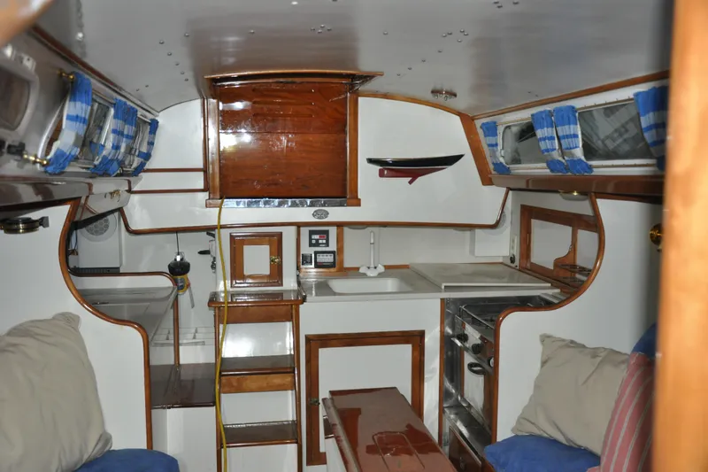 Slide: The Image of Interior of a 1970 Hinckley Bermuda 40 sailboat, featuring wood accents and cozy seating. - 19