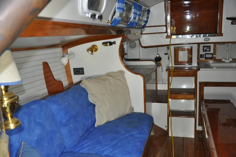 Slide: The Image of Interior of a 1970 Hinckley Bermuda 40 sailboat with blue seating and wooden accents. - 24