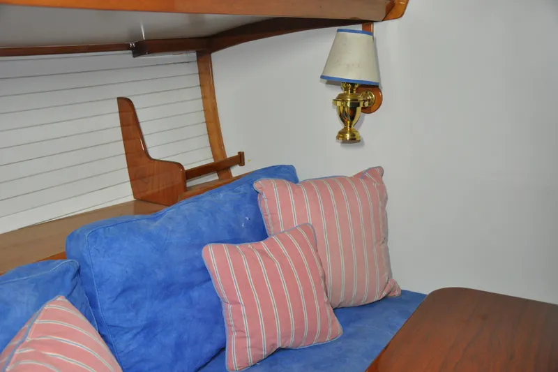 Slide: The Image of Interior of 1970 Hinckley Bermuda 40 with blue sofa, striped pillows, and brass wall lamp. - 25