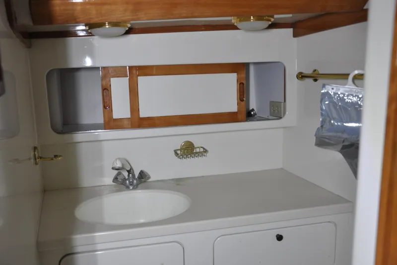 Slide: The Image of 1970 Hinckley Bermuda 40 yacht bathroom with sink, wooden accents, and storage. - 37