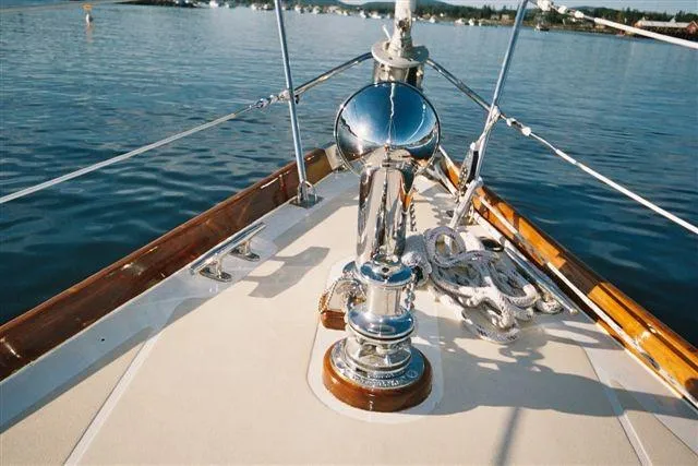 Slide: The Image of Hinckley Bermuda 40 sailboat deck with polished winch, 1970 model, on calm water. - 4