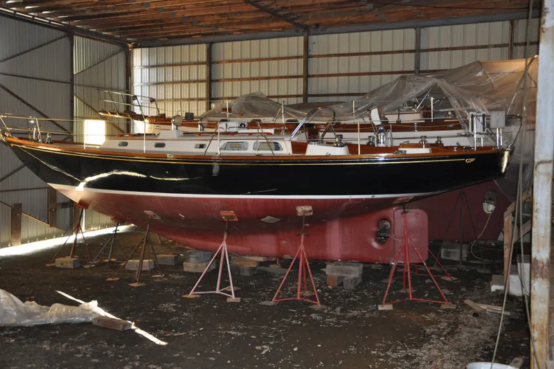 Slide: The Image of 1970 Hinckley Bermuda 40 sailboat in storage, supported by stands in a shed. - 5