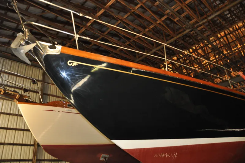Slide: The Image of 1970 Hinckley Bermuda 40 sailboat in storage, showcasing sleek hull design. - 8