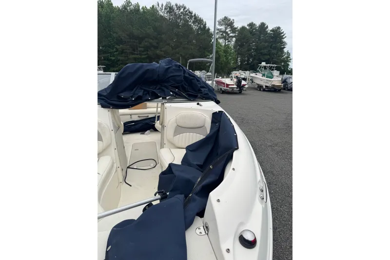 Slide: The Image of 2013 Stingray 204 LR boat with blue cover in a parking lot. - 10