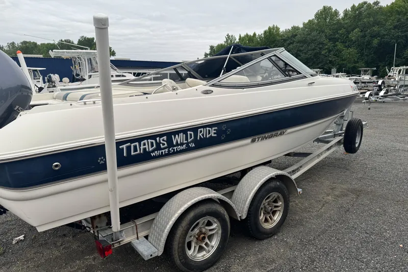 Slide: The Image of 2013 Stingray 204 LR boat on trailer, labeled "Toad's Wild Ride," in a marina setting. - 4