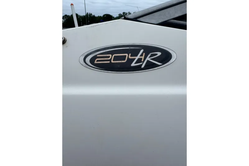 Slide: The Image of 2013 Stingray 204 LR logo on white boat exterior. - 5